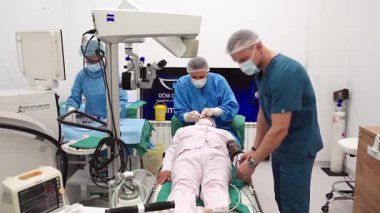 Yetenekli cerrah ve tıbbi ekibi yaşlı bir hastaya hassas bir göz ameliyatı yaparak en son tıbbi teknoloji ve ileri teknoloji ile görme yetisini geri kazandırıyor. Modern göz ameliyatı konsepti.