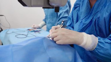 Yetenekli cerrah ve tıbbi ekibi yaşlı bir hastaya hassas bir göz ameliyatı yaparak en son tıbbi teknoloji ve ileri teknoloji ile görme yetisini geri kazandırıyor. Modern göz ameliyatı konsepti.