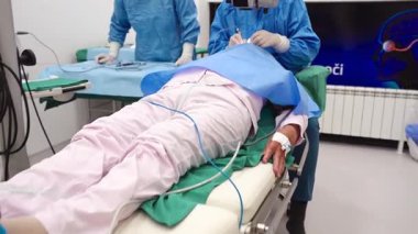 Yetenekli cerrah ve tıbbi ekibi yaşlı bir hastaya hassas bir göz ameliyatı yaparak en son tıbbi teknoloji ve ileri teknoloji ile görme yetisini geri kazandırıyor. Modern göz ameliyatı konsepti.