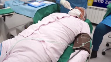 Yetenekli cerrah ve tıbbi ekibi yaşlı bir hastaya hassas bir göz ameliyatı yaparak en son tıbbi teknoloji ve ileri teknoloji ile görme yetisini geri kazandırıyor. Modern göz ameliyatı konsepti.