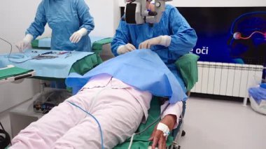 Yetenekli cerrah ve tıbbi ekibi yaşlı bir hastaya hassas bir göz ameliyatı yaparak en son tıbbi teknoloji ve ileri teknoloji ile görme yetisini geri kazandırıyor. Modern göz ameliyatı konsepti.