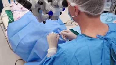 Yetenekli cerrah ve tıbbi ekibi yaşlı bir hastaya hassas bir göz ameliyatı yaparak en son tıbbi teknoloji ve ileri teknoloji ile görme yetisini geri kazandırıyor. Modern göz ameliyatı konsepti.