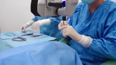 Yetenekli cerrah ve tıbbi ekibi yaşlı bir hastaya hassas bir göz ameliyatı yaparak en son tıbbi teknoloji ve ileri teknoloji ile görme yetisini geri kazandırıyor. Modern göz ameliyatı konsepti.