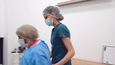 Yetenekli cerrah ve tıbbi ekibi yaşlı bir hastaya hassas bir göz ameliyatı yaparak en son tıbbi teknoloji ve ileri teknoloji ile görme yetisini geri kazandırıyor. Modern göz ameliyatı konsepti.