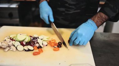 Lokanta mutfağında çalışan profesyonel şefin ellerini yakın plan çek. O, balık ve deniz ürünleriyle sağlıklı lezzetli yemekler hazırlar..