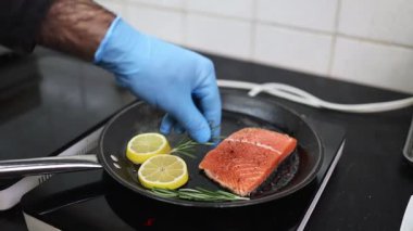 Lokanta mutfağında çalışan profesyonel şefin ellerini yakın plan çek. O, balık ve deniz ürünleriyle sağlıklı lezzetli yemekler hazırlar..