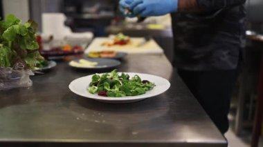 Lokanta mutfağında çalışan profesyonel şefin ellerini yakın plan çek. O, balık ve deniz ürünleriyle sağlıklı lezzetli yemekler hazırlar..