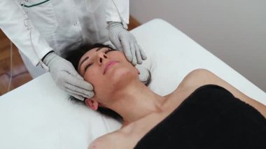 Yüz ve vücut elektrot uyarıcısı için iletken eldivenlerle mikro duyusal BIO EMS mikro akım tedavisi. Kırışıklık önleyici ve yaşlanma önleyici. Seçici odak. 