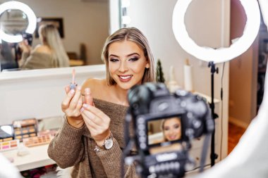 Güzel bayan çevrimiçi içerik kozmetikçisi makyaj yapıyor ve izleyicilere bazı iş araçlarını açıklıyor. Günlük kaydı ve çevrimiçi kanal çalışması. 