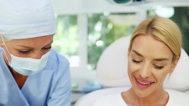 Güzellik kliniğindeki güzel kadın. Oturup kadın doktorla yüz estetiği hakkında konuşuyor. Güvenilir ve mutlu..