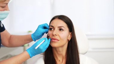 Güzel esmer kadın hasta botulinyum toksin iğneleri ya da hyaluronik asit doldurucu ile tıbbi ve güzellik tedavisine hazırlanıyor..