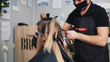 Kuaför kadın saçı boyuyor, müşterisine folyoyla saç renkleri yapıyor. Modern saç stili ve moda konsepti.