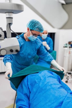 Yetenekli tıbbi ekip yaşlı bir hastaya hassas bir göz ameliyatı yapmaya hazırlanıyor, en son tıbbi teknoloji ve ileri teknolojilerle vizyonu geri getiriyorlar. Modern göz ameliyatı konsepti.
