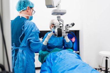 Yetenekli tıbbi ekip yaşlı bir hastaya hassas bir göz ameliyatı yapmaya hazırlanıyor, en son tıbbi teknoloji ve ileri teknolojilerle vizyonu geri getiriyorlar. Modern göz ameliyatı konsepti.