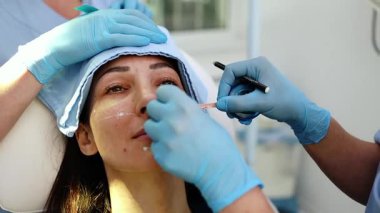 Güzel esmer kadın hasta botulinyum toksin iğneleri ya da hyaluronik asit doldurucu ile tıbbi ve güzellik tedavisine hazırlanıyor..