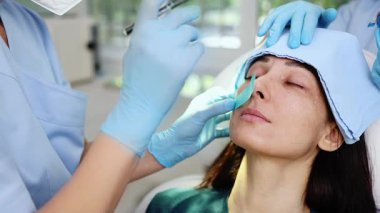 Güzel esmer kadın hasta botulinyum toksin iğneleri ya da hyaluronik asit doldurucu ile tıbbi ve güzellik tedavisine hazırlanıyor..