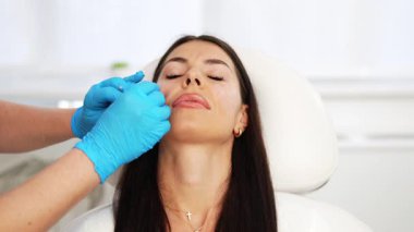 Güzellik uzmanları cerrahi güzellik tedavisine hazırlanıyorlar. Yüz elmacık kemikleri, hyaluronik asit dolgusu ile doluyor. Modern güzellik cerrahisi konsepti.