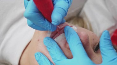 Profesyonel kalıcı makyaj prosedürü. Modern güzellik salonunda dövmeli dudak makyaj tedavisi. Yakın çekim..