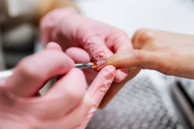 Modern bir güzellik salonunda çalışan profesyonel bir manikürcü. Kadın müşteri kaplıca merkezinde manikür tedavisi görüyor. Yakın çekim..