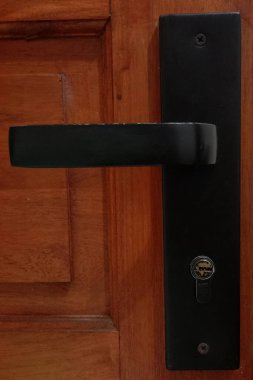 Siyah demir kapı kolu, ahşap kapılı.