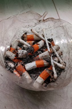 Kül tablaları ve sigara izmaritleriyle dolu.