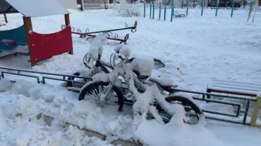 Karla kaplı bisikletler, dondurucu kış koşullarında donmuş, derin dondurucu soğukta terk edilmiş olarak dururlar. Yakutsk, Rusya 'da kışın şiddetini gösteren soğuk bir hava manzarası..