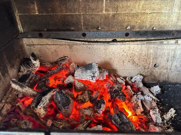 Parlayan közleri ve yanan kömürleriyle barbekü arka planını gösteren canlı bir görüntü, sıcak ve davetkar bir ışıltı yaratıyor. Kömürün sert dokusu kızılımsı alevlerle çelişiyor. Hoş bir karşılama hissi uyandırıyor. Yaz barbeküsü için mükemmel.