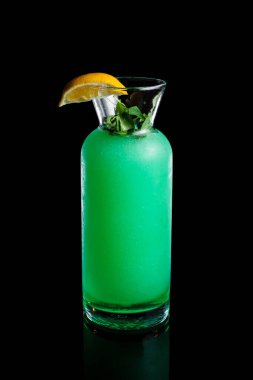 Ev yapımı naneli limonata ve siyah arka planda cam bir şişe limon. Yüksek kalite fotoğraf