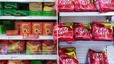 Yer: Keningau, Sabah, Malezya. Tarih: 1 Şubat 2025. Konu: Süpermarket raflarında Sabah Çayı, BOH ve KitKat Chocolatees gibi çeşitli markalar var. 1 Şubat 2025 'te Keningau, Sabah, Malezya' da, bu resim süpermarketlerinde