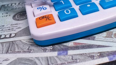 Dolarlar üzerindeki hesap makinesi, film bütçesini ve finansal planlamayı sembolize ediyor.