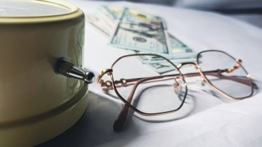 Saat, gözlük ve aksesuar parası vizyonun ve finansal başarının planlanmasının önemini sembolize eder..