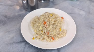 Kızarmış tavuklu pilav, içinde pirinç havucu, mısır ve yumurta bulunan beyaz bir tabakta oturur. Öğle ve akşam yemekleri için mükemmel ve dengeli bir yemek seçeneği sunar. Asya mutfağı gelenekleri ve...