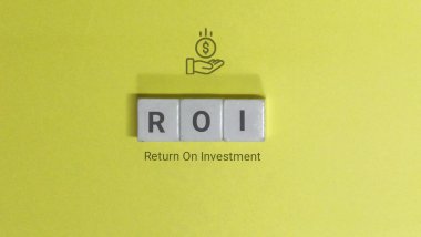 ROI letters are displayed with a money icon on a yellow background representing return on investment and financial success. Return on investment is a key metric for evaluating the efficiency of an in