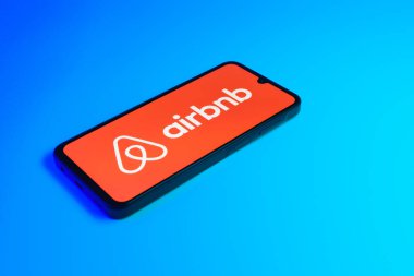 Prag, Çek: Mavi yüzey arka planında Airbnb logosuna sahip modern akıllı telefon aygıtı.