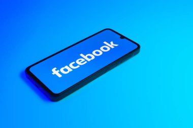 Prag, Çek: Mavi zemin üzerinde Facebook logosuna sahip modern akıllı telefon aygıtı.