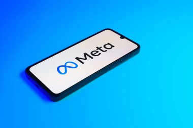 Prag, Çek: Mavi yüzey arka planında meta logolu modern akıllı telefon aygıtı.