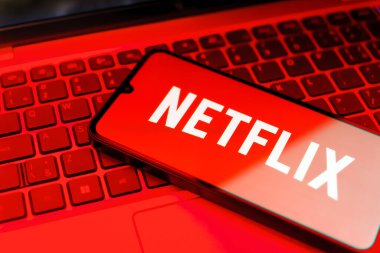 Prag, Çek: Arka planda dizüstü bilgisayarı ve logo netflix 'i olan modern akıllı telefon 