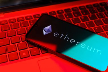 Prag, Çek: Arka planda dizüstü bilgisayarı ve logo ethereum ekranı olan modern akıllı telefon 