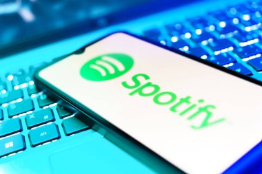 Prag, Çek Cumhuriyeti - 21 Ekim 2024: Laptop klavye arkaplanındaki modern akıllı telefon aygıtı benekli logoyu gösteriyor.