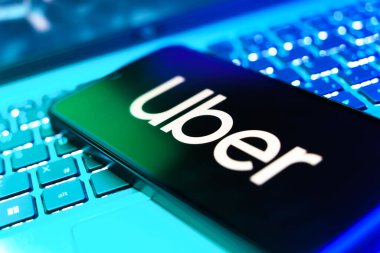 Prag, Çek Cumhuriyeti - 21 Ekim 2024: Laptop klavyesinde Uber logosu gösteren modern akıllı telefon aygıtı.