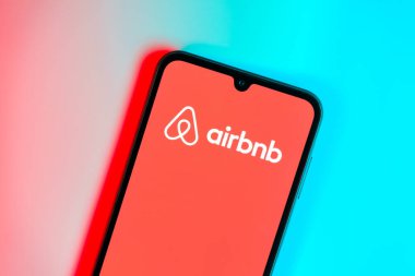 Prag, Çek: Mavi yüzey arka planında Airbnb logosuna sahip modern akıllı telefon aygıtı.