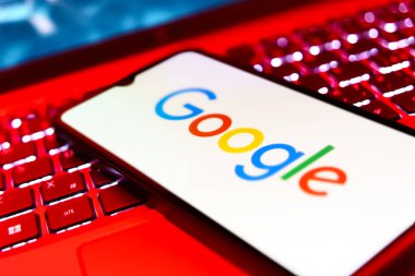 Prag, Çek: Logolu modern akıllı telefon ekranda google ve arka planda dizüstü bilgisayar 