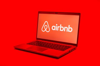 Prag, Çek Cumhuriyeti - 21 Ekim 2024: Yüzey arkaplanındaki modern laptop ekranı Airbnb logosunu gösteriyor