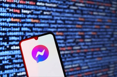 Prag, Çek: Facebook kurye logosuna sahip modern akıllı telefon ekranda ve arka planda bilgisayar ekranı var 