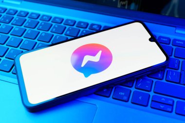 Prag, Çek Cumhuriyeti - 21 Ekim 2024: Laptop klavye arka planında kurye logosu gösteren modern akıllı telefon aygıtı.