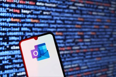 Prag, Çek: Ekranda logo görünümlü modern akıllı telefon ve arka planda bilgisayar ekranı 