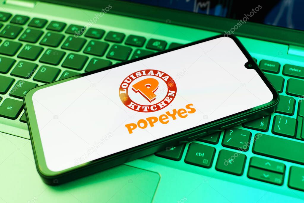 Prague, Czechia - 10 21 2024: Smartphone on surface showing Popeyes logo.