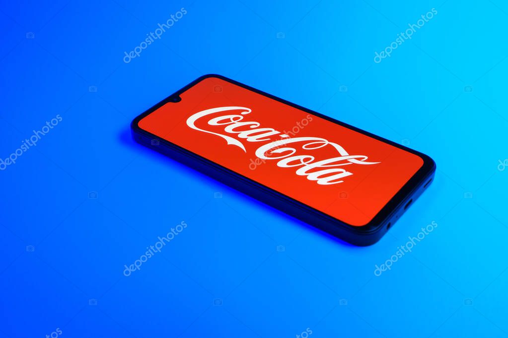 Prague, Czechia - 10 21 2024: Smartphone on surface showing Coca-Cola logo.