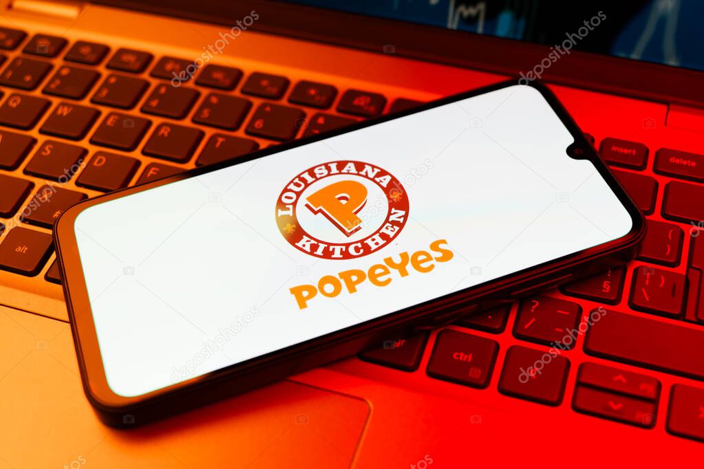 Prague, Czechia - 10 21 2024: Smartphone on surface showing Popeyes logo.