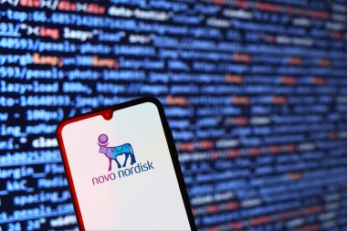 Prag, Çek: Ekranda logo novo rordisk ve arka planda bilgisayar ekranı olan modern akıllı telefon 